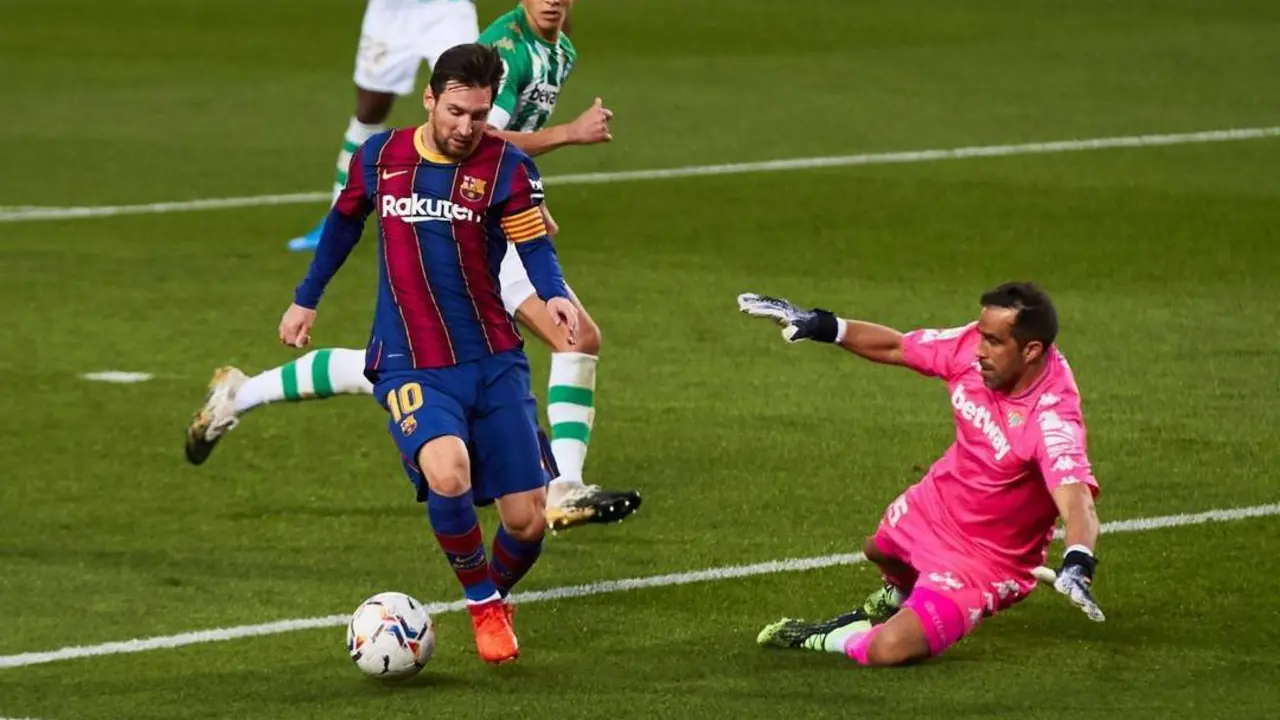Los futbolistas del Real Betis, Claudio Bravo y Aissa Mandi, intentan tapar un disparo de Messi. - efe