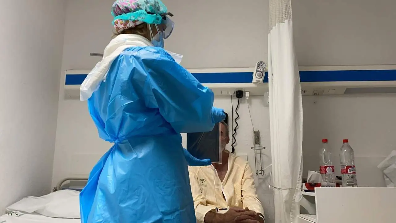 Un sanitaria atiende a un paciente en el Hospital Regional de M&aacute;laga. - Junta de Andaluc&iacute;a