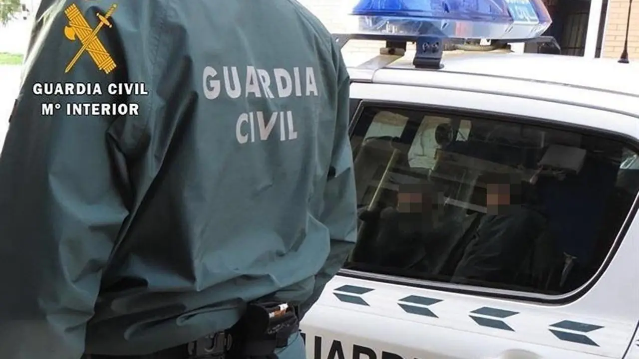 Un agente de la Guardia Civil junto a un coche patrulla. - EP
