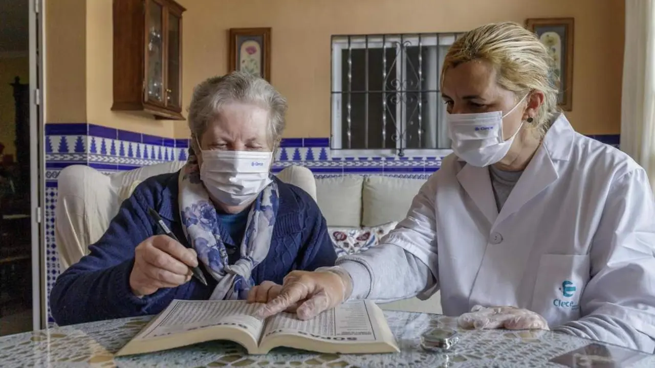 Isabel junto a una usuaria. - AI