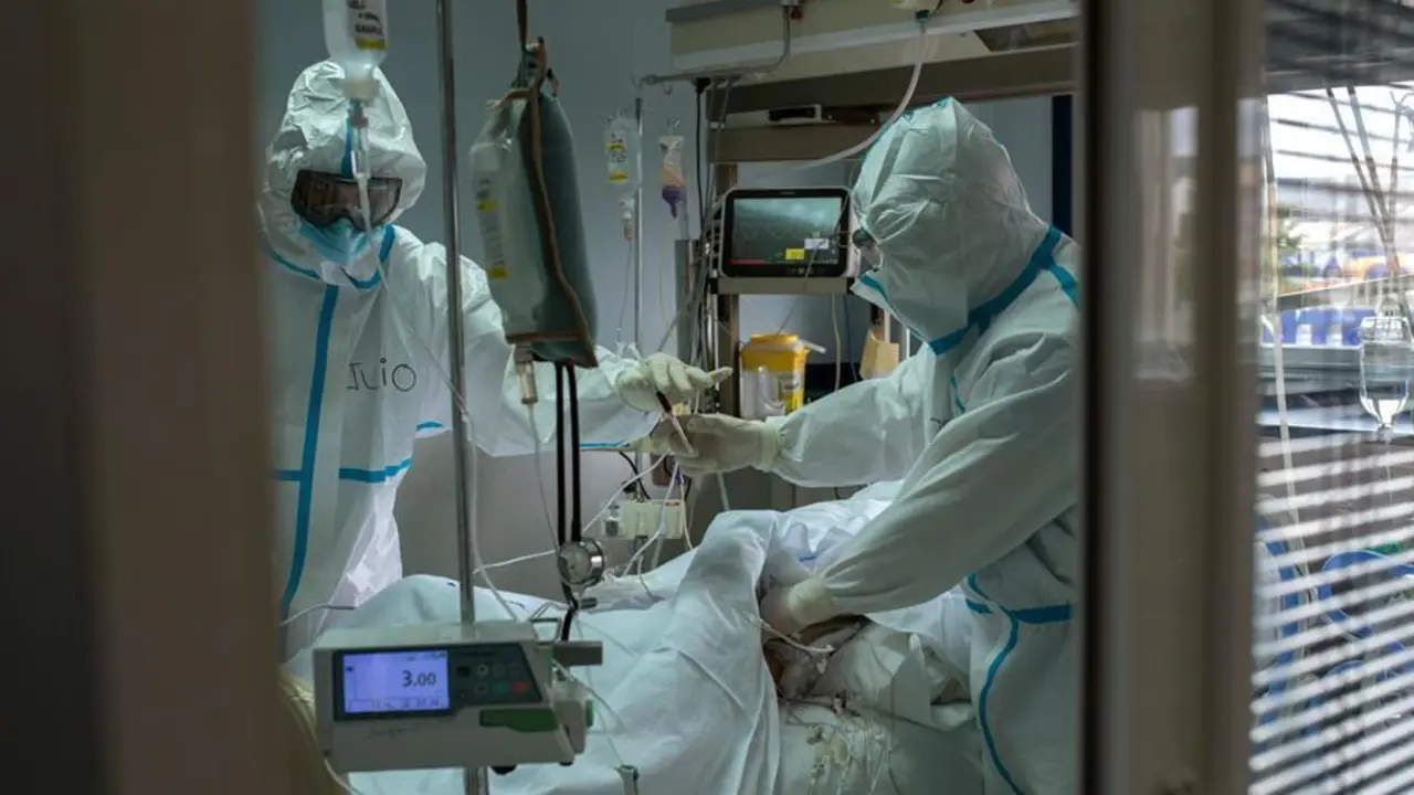 Trabajadores sanitarios atienden a un paciente con coronavirus en la UCI. - EFE