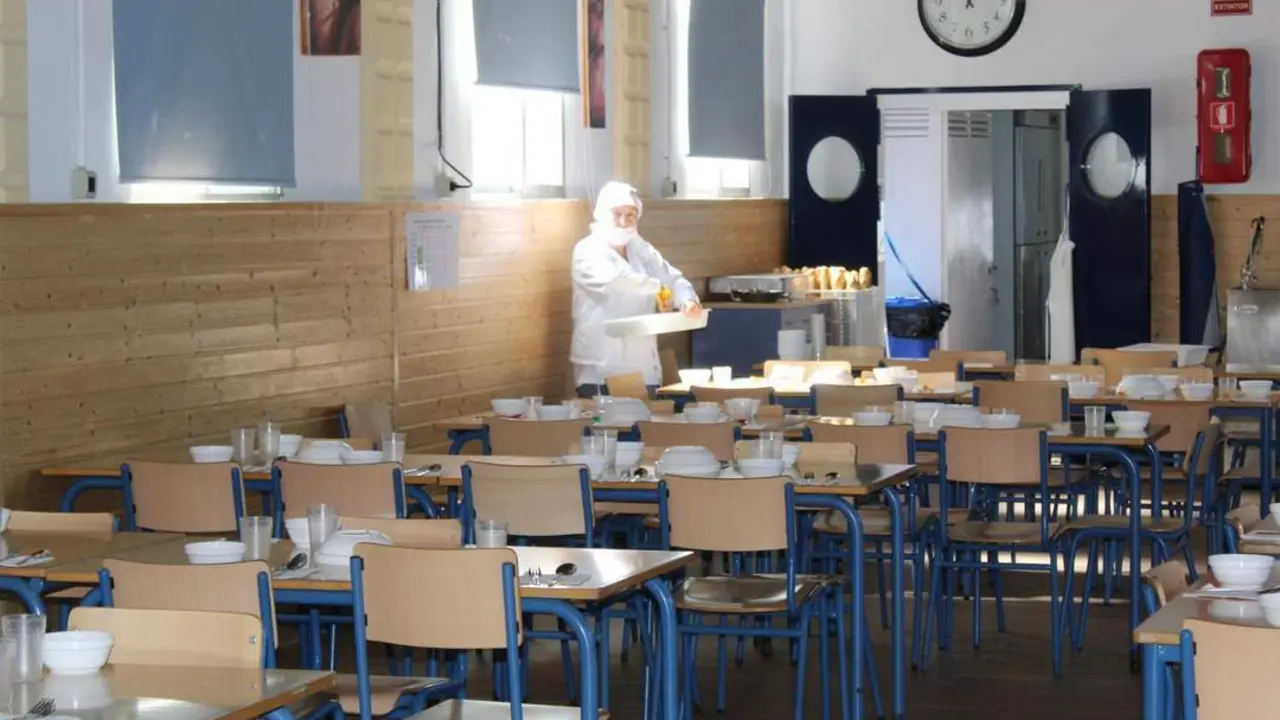 Una cocinera preparando las mesas del Comedor del CEIP Maestra Caridad Ruiz - Ra&uacute;l J. Bustillos