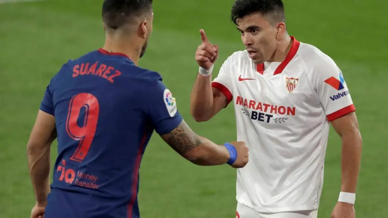 El lateral izquierdo del Sevilla, Marcos Acu&ntilde;a, discute con Luis Su&aacute;rez durante un partido contra el Atleti. - efe