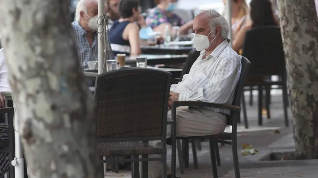 Personas con mascarillas en una terraza. - ep