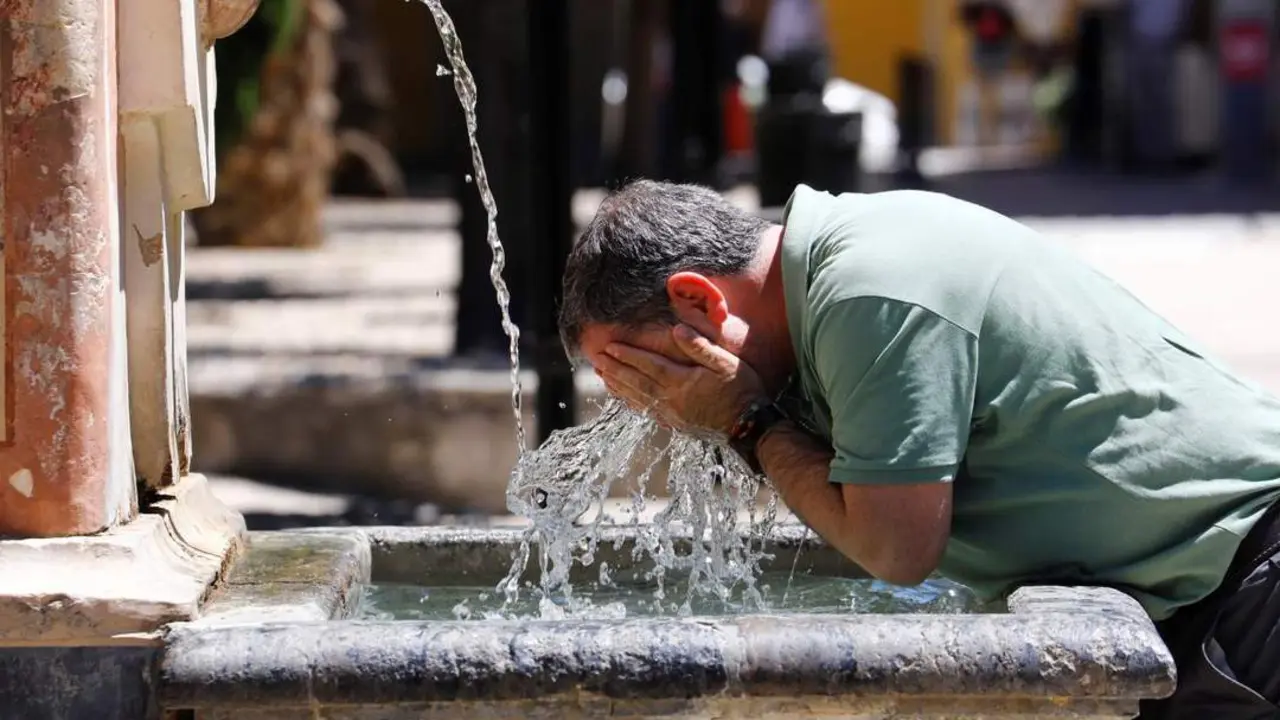 Un andaluz se refresca en una fuente de C&oacute;rdoba. - EFE