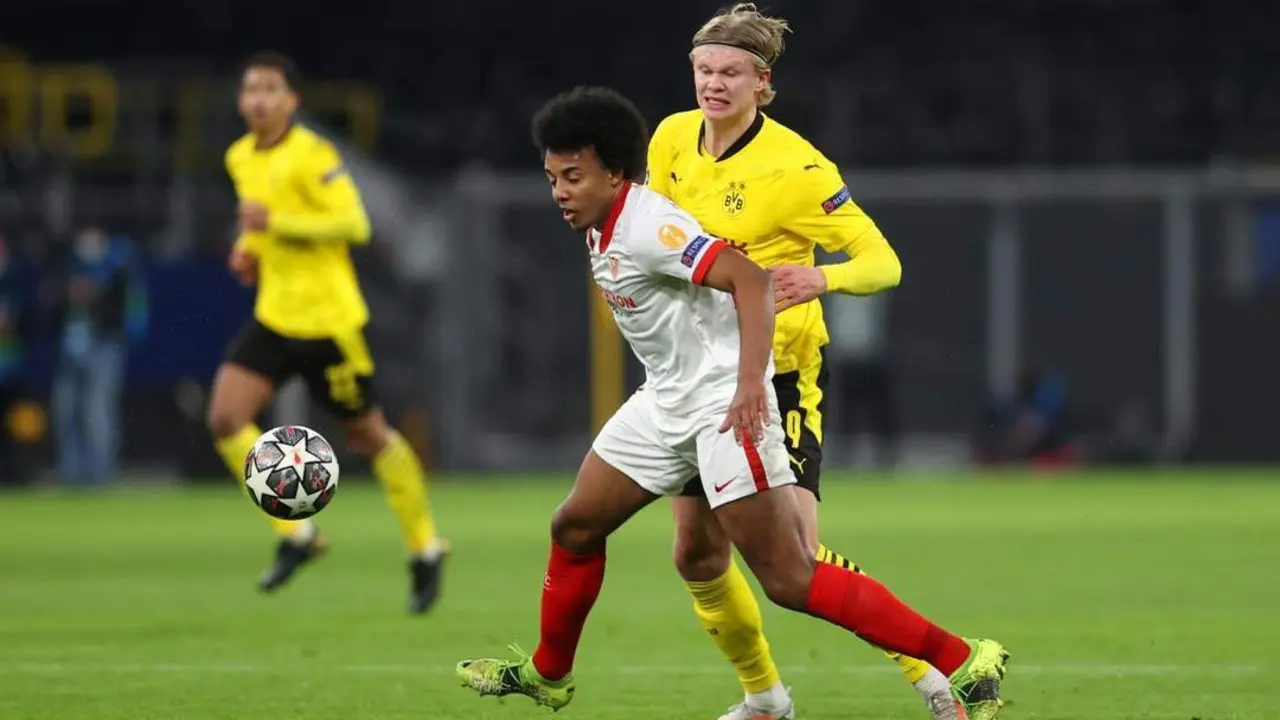 El futbolista del Sevilla, Kound&eacute;, protege el bal&oacute;n ante Haaland. - efe