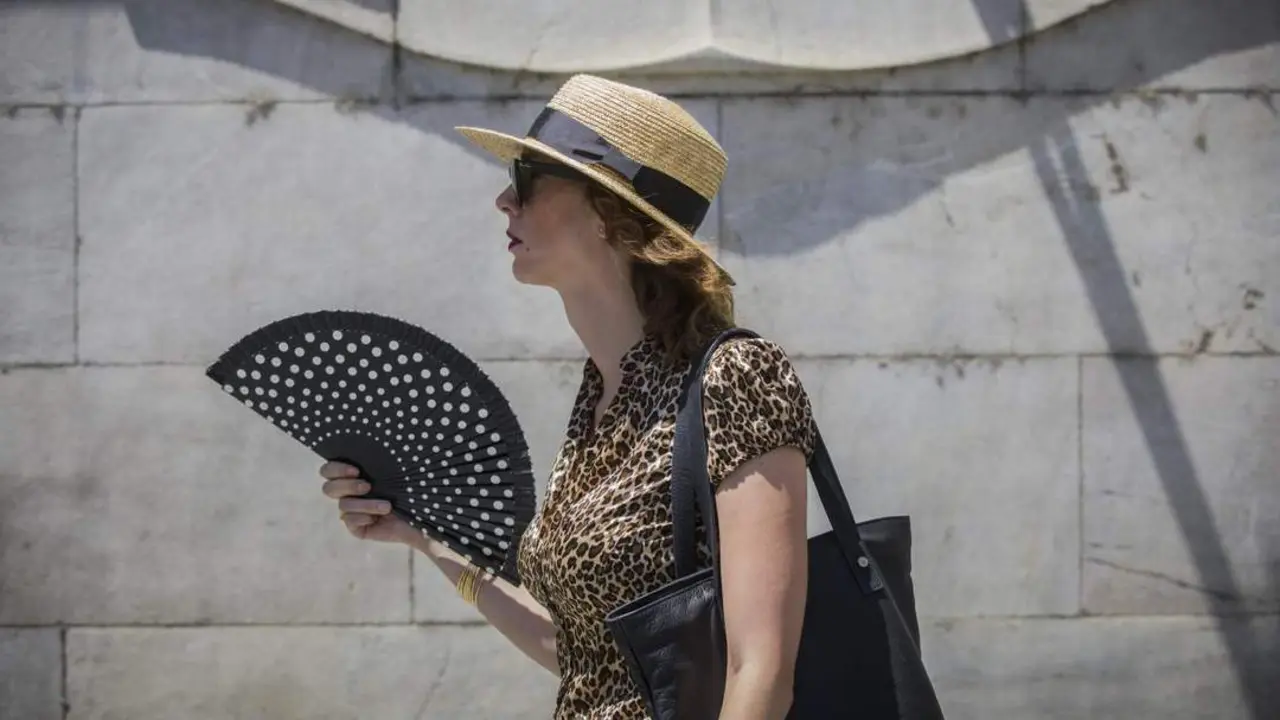 Una mujer se abanica mientras pasea por la calle. - Europa Press