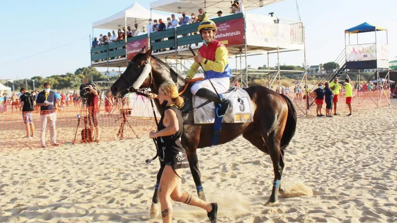 Jaime Gelabert hace la se&ntilde;al de victoria tras ganar el GP Ciudad de Sanl&uacute;car y por pasar a la historia - Ra&uacute;l J. Bustillos