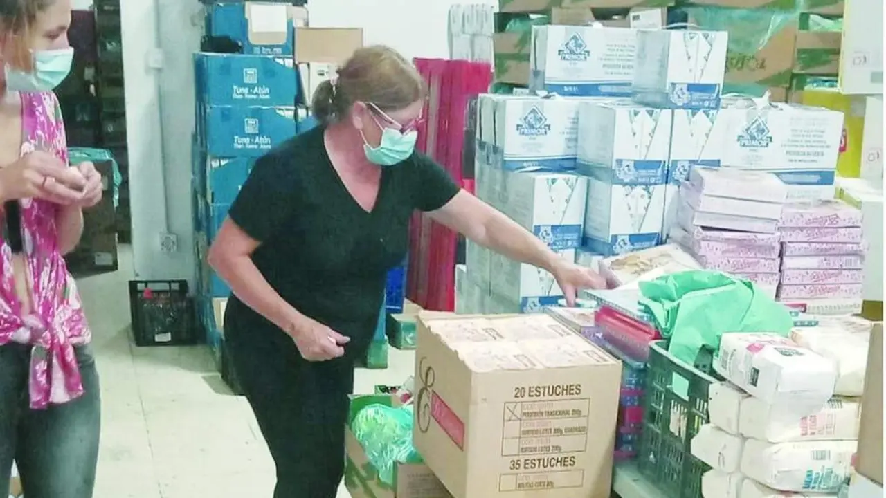 Dos voluntarias ayudan a organizar la comida de la Asociaci&oacute;n Lagunillas, en la capital malague&ntilde;a, que cada d&iacute;a da de comer a m&aacute;s gente. - Cedida