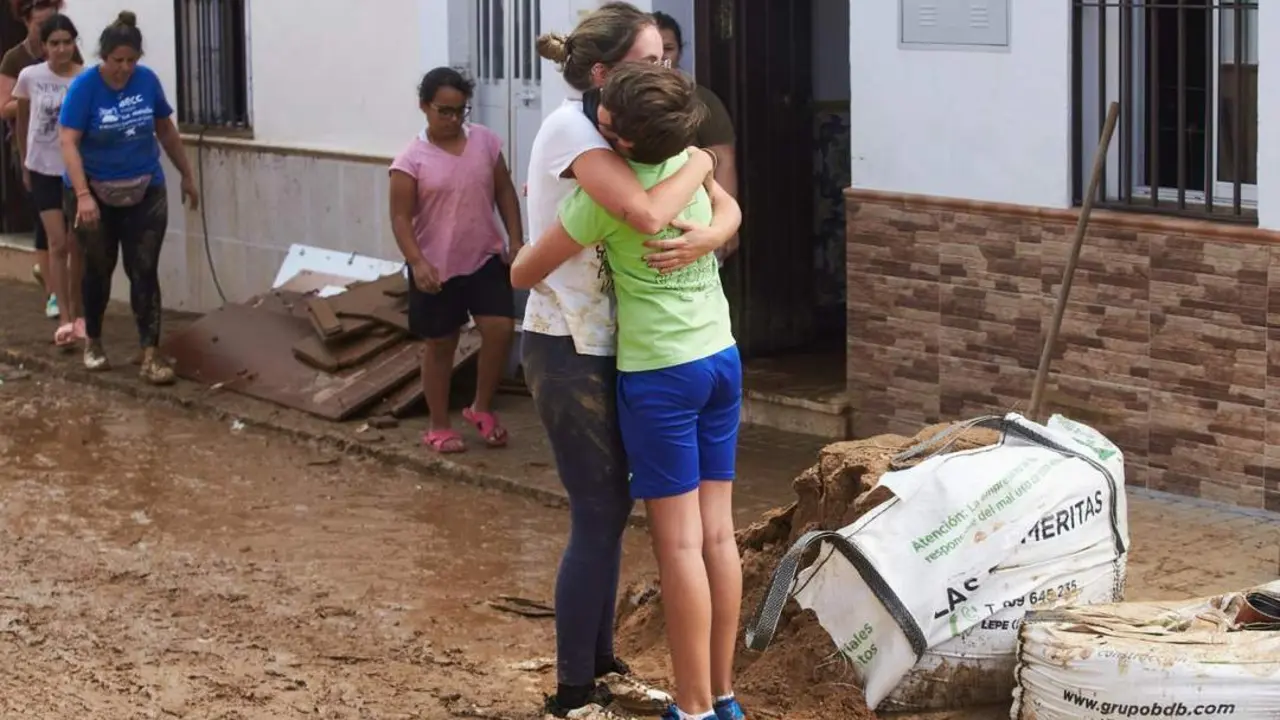 Un abrazo durante las tareas de limpieza en las calles en Lepe. - EP