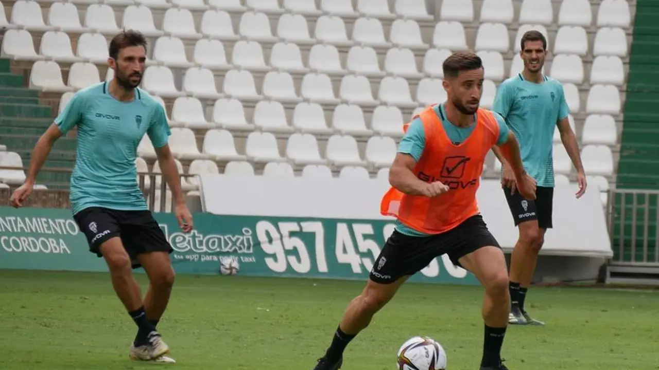 Omar Perdomo conduce un bal&oacute;n ante la mirada de Alex Bernal durante un entrenamiento - | C&oacute;rdoba CF