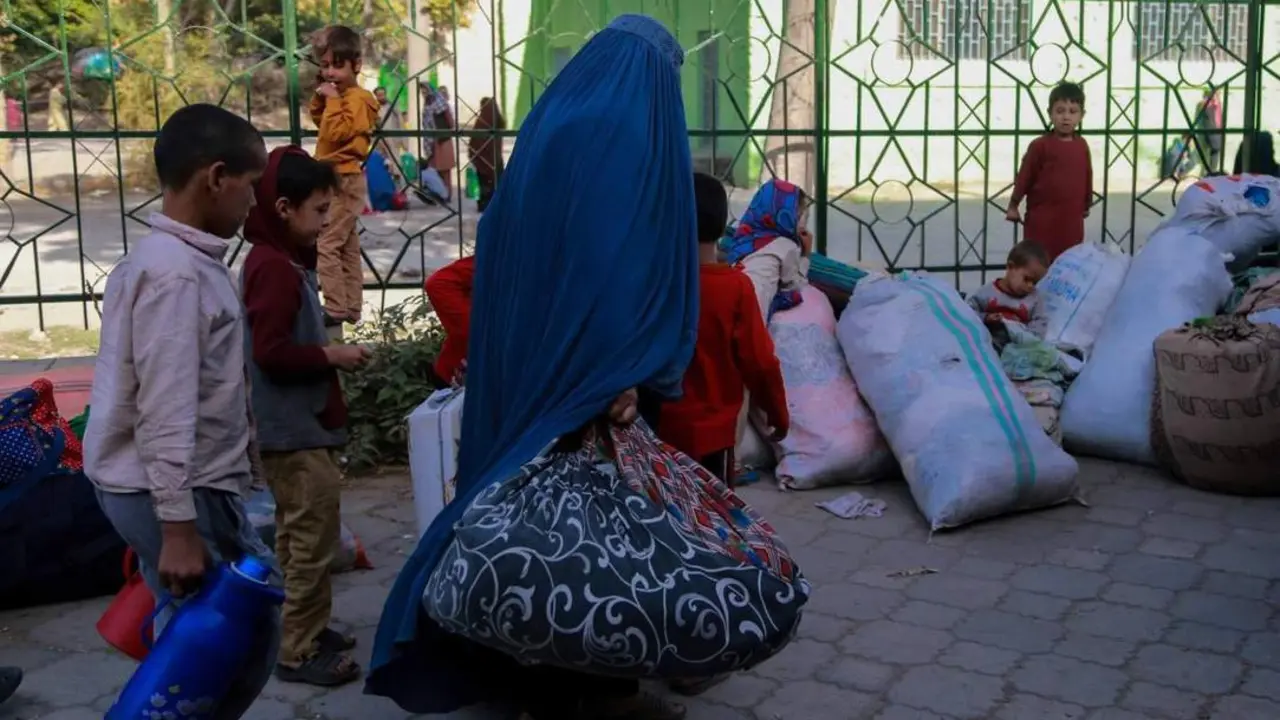 Familias afganas preparan y trasladan sus bolsas de equipajes.  - EFE