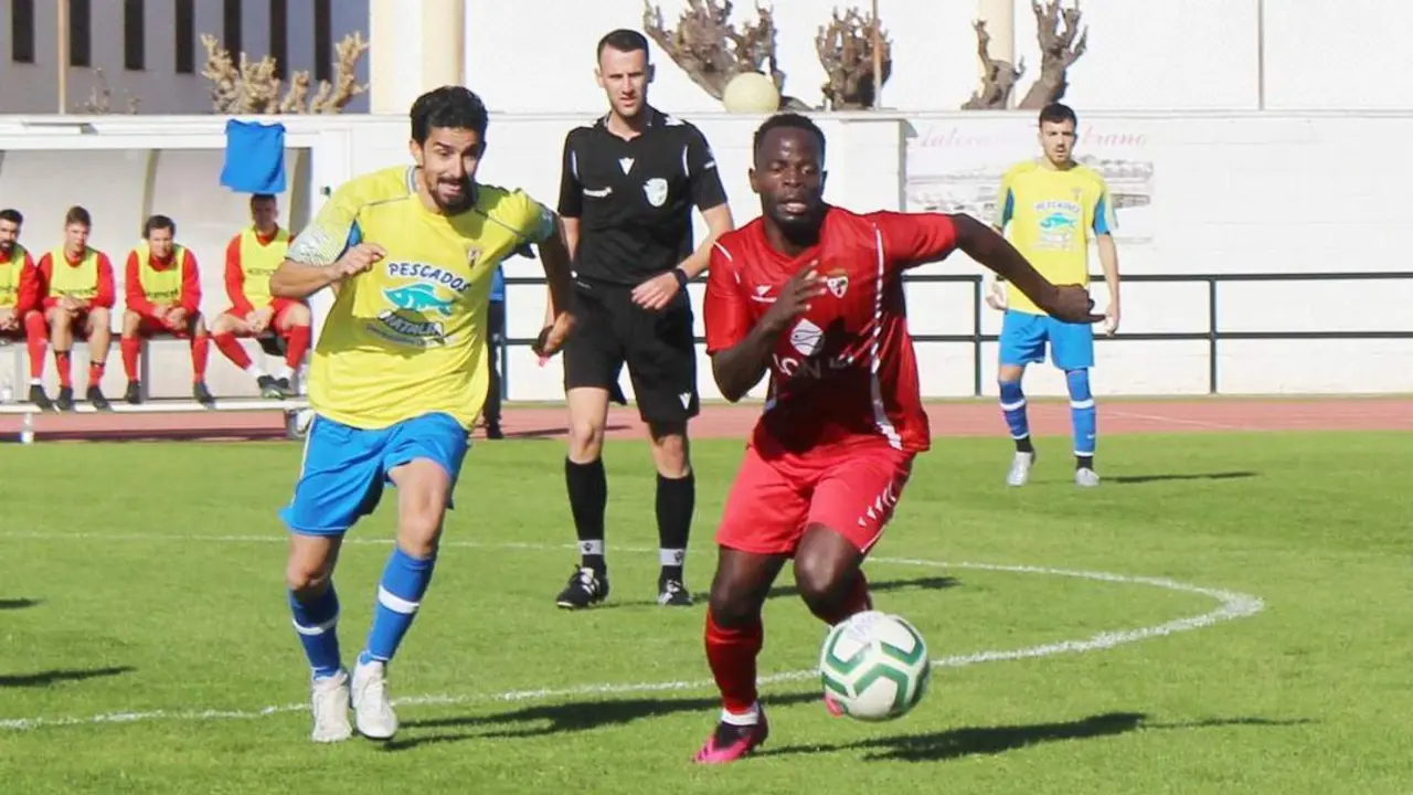 Ismael Cordero, autor del 1-0, pugna con un jugador el Recreativo Portuense en la lucha por controlars el bal&oacute;n - Ra&uacute;l j. Bustillos