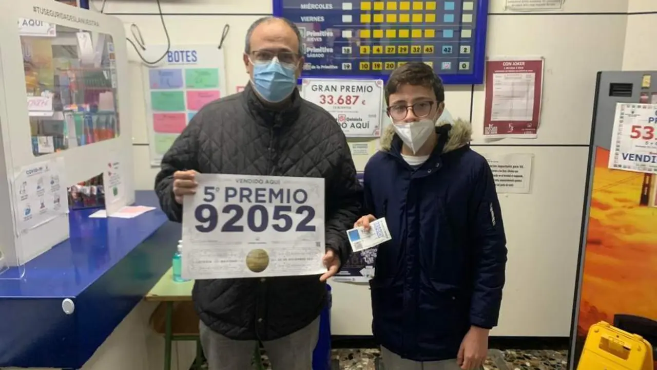 C&aacute;ndido junto a su hijo mostrando el d&eacute;cimo ganador del quinto premio - A. Bernal