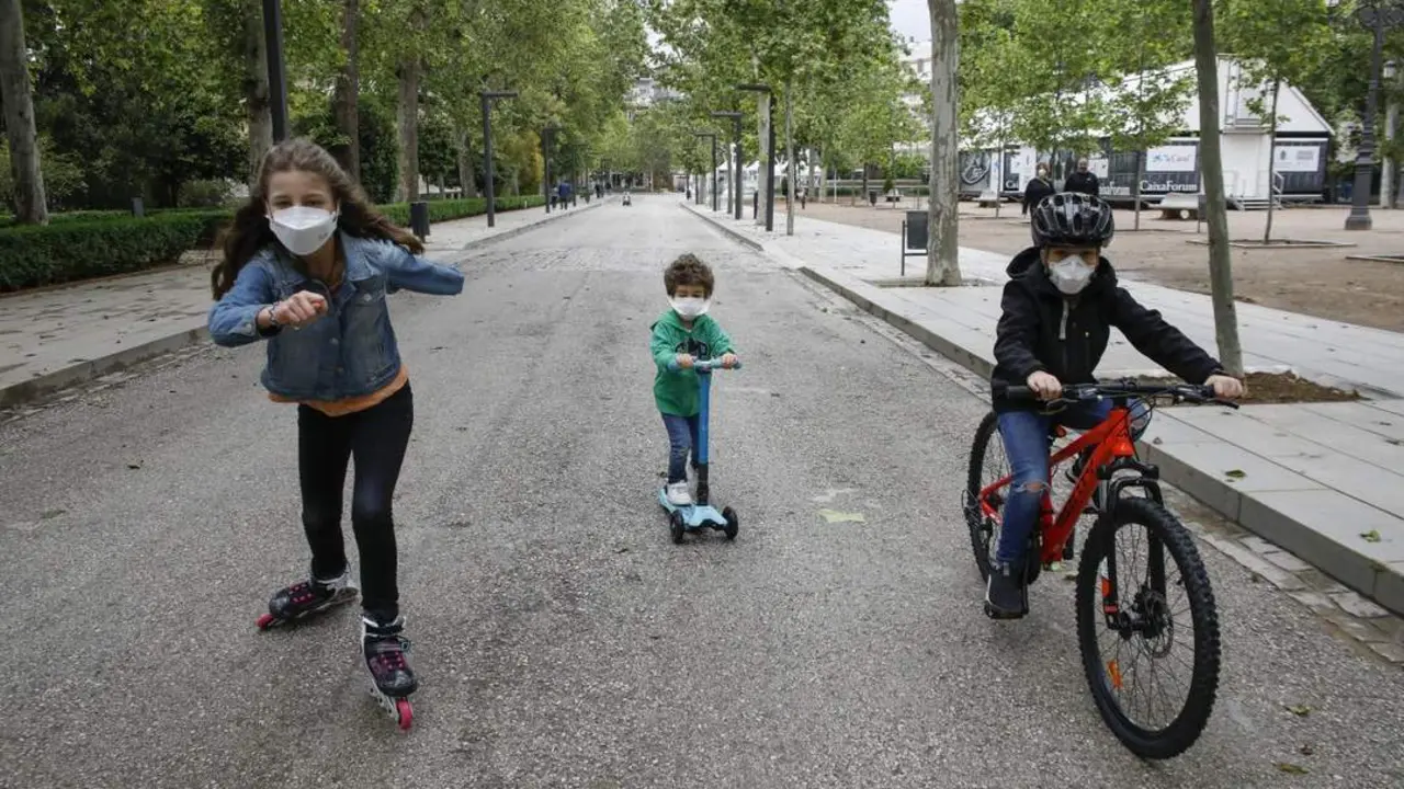 Tres ni&ntilde;os practican deporte al aire libre protegidos con mascarillas. - EP