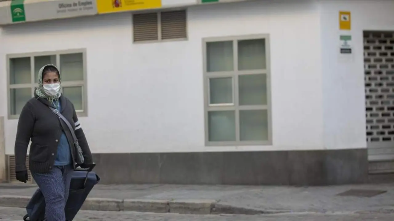 Una mujer portando un carro de la compra camina delante de una Oficina de Empleo. - MAR&Iacute;A JOS&Eacute; L&Oacute;PEZ / EUROPA PRESS