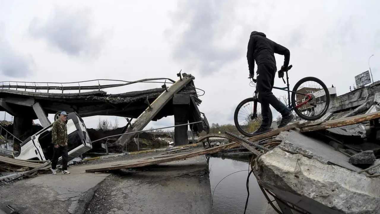 Un hombre cruza un puente derribado en Irpin. - efe