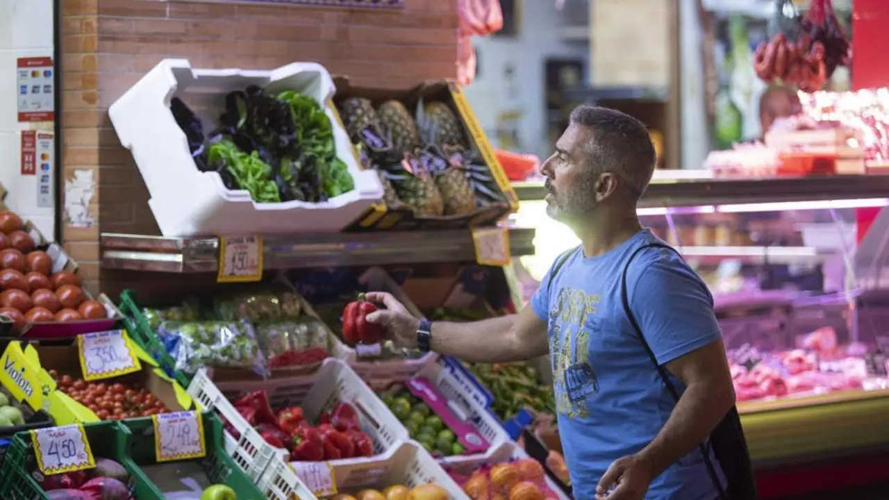 Un hombre comprando en un mercado de abastos de Triana. - Europa Press