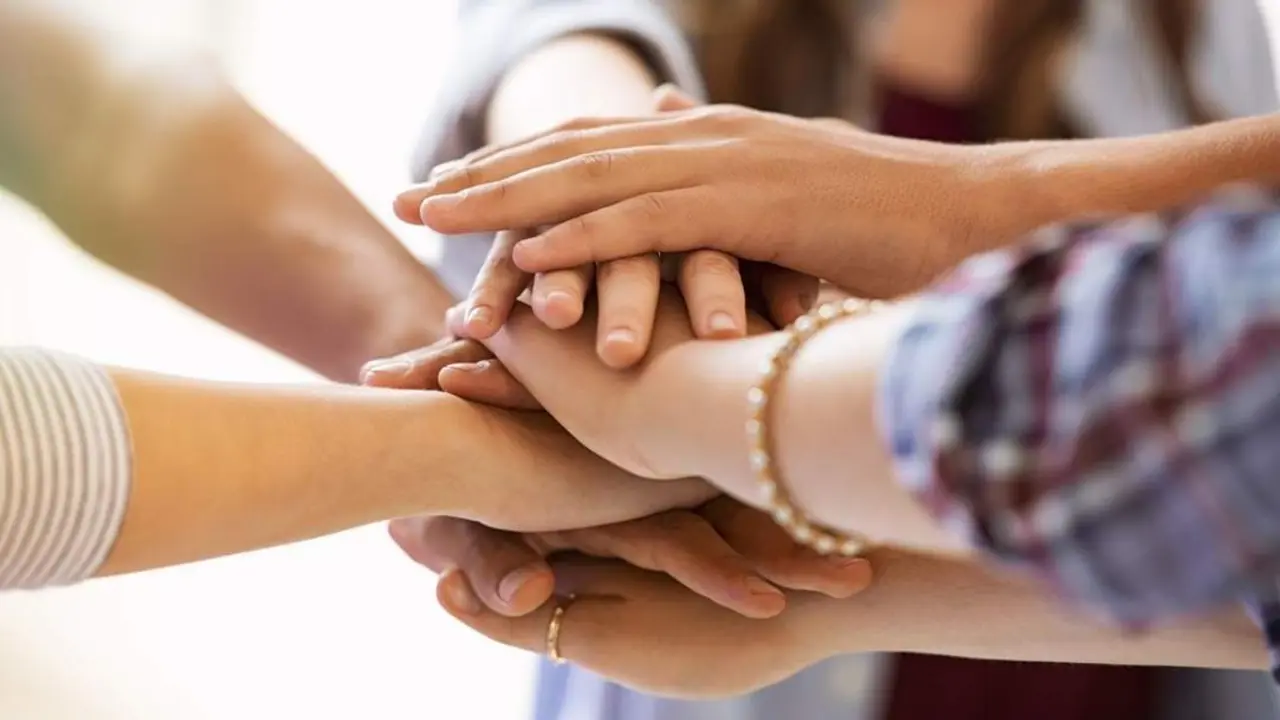  Varias mujeres unen sus manos. - 
