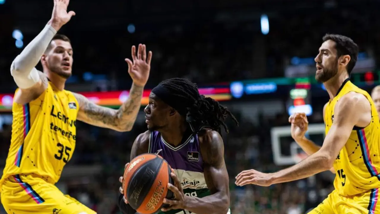 El base de Unicaja Kendrick Perry defendido por dos rivales. - EFE/Carlos D&iacute;az