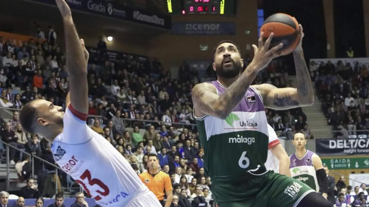 El ala-p&iacute;vot brasile&ntilde;o del Unicaja Augusto Lima (d) entra a canasta ante la oposici&oacute;n de Phil Srubb (i), escolta canadiense-brit&aacute;nico del Obradoiro. - EFE