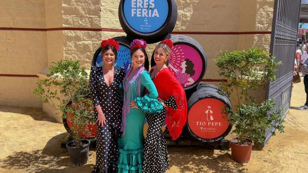 Mujeres vestidqs de flamenca  en la portada principal. - A.L.
