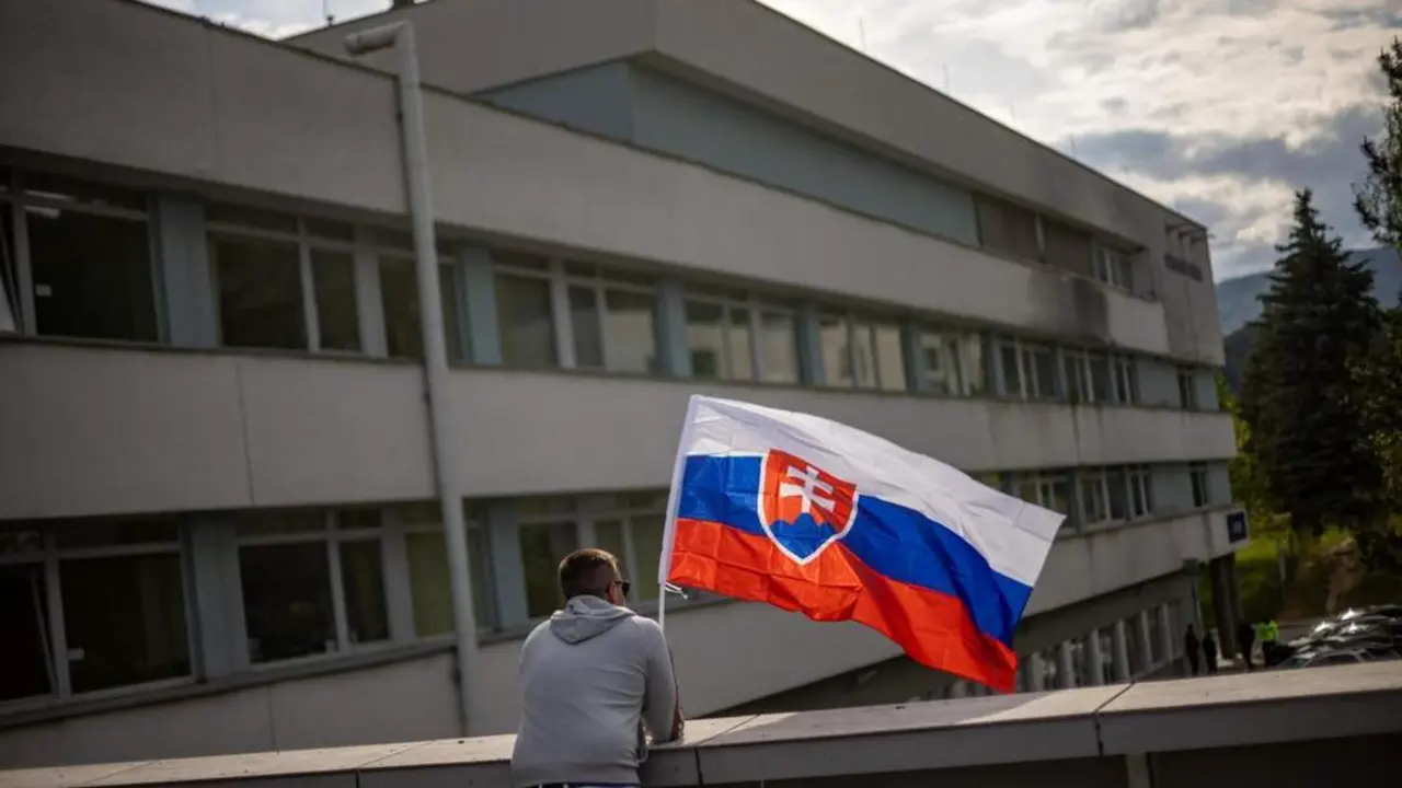 Un eslovaco con la bandera de su pa&iacute;s, ante el hospital. - EFE