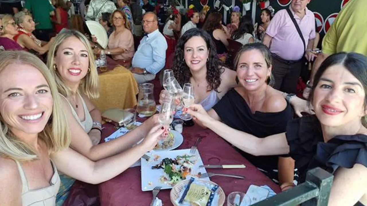 Varias mujeres brindan con Manzanilla en la Feria de Sanl&uacute;car - AI