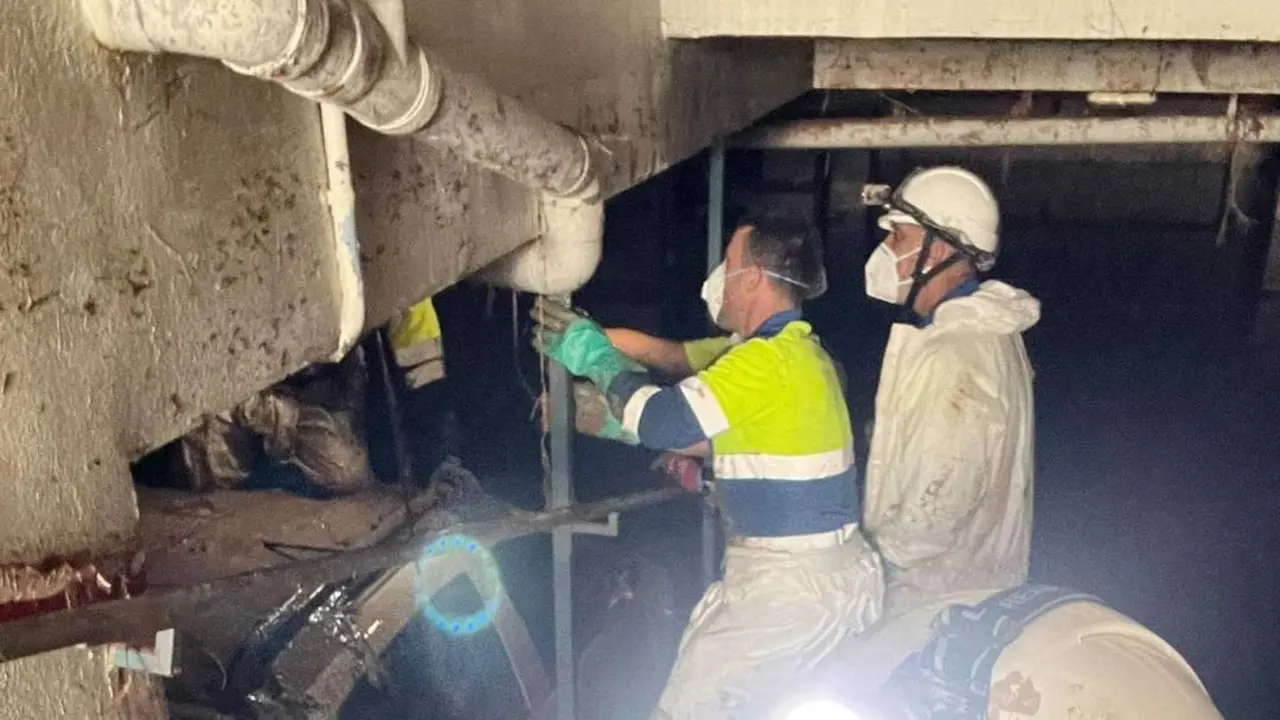 Salvador Palma sujetando una tuber&iacute;a en un garaje inundado - AI