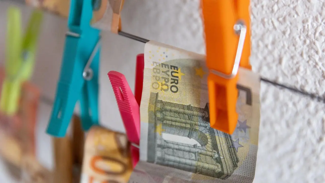 Varios billetes sujetos con pinzas. - Europa Press.