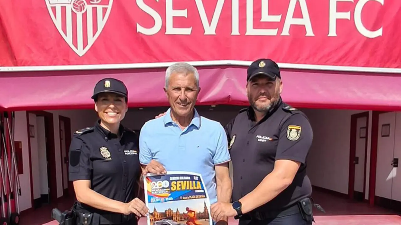 Pablo Blanco y dos agentes de la Polic&iacute;a Nacional posan con el cartel de la carrera. | DGP.