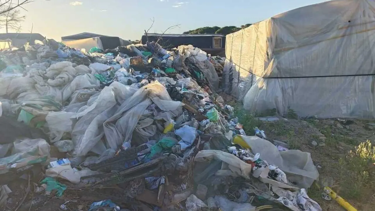Basura en el asentamiento de Lucena del Puerto. | APDHA.