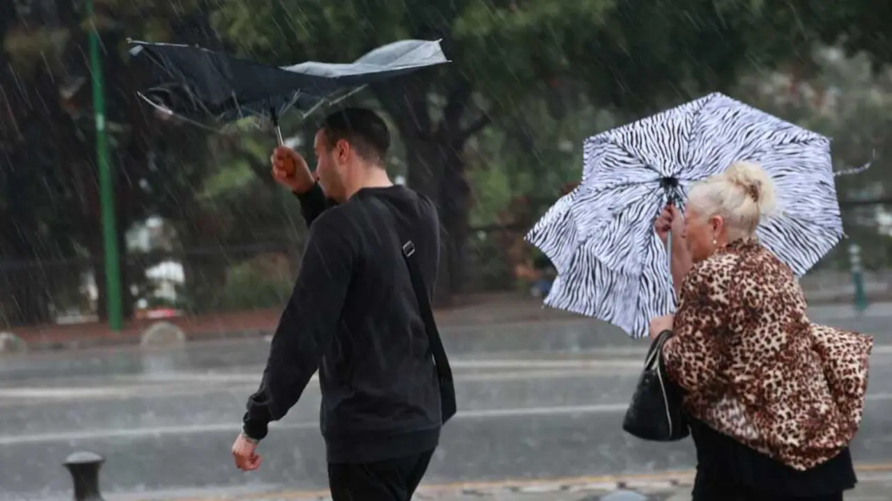 Sevillanos refugi&aacute;ndose de la lluvia y el viento. | Roc&iacute;o Ruz - Europa Press