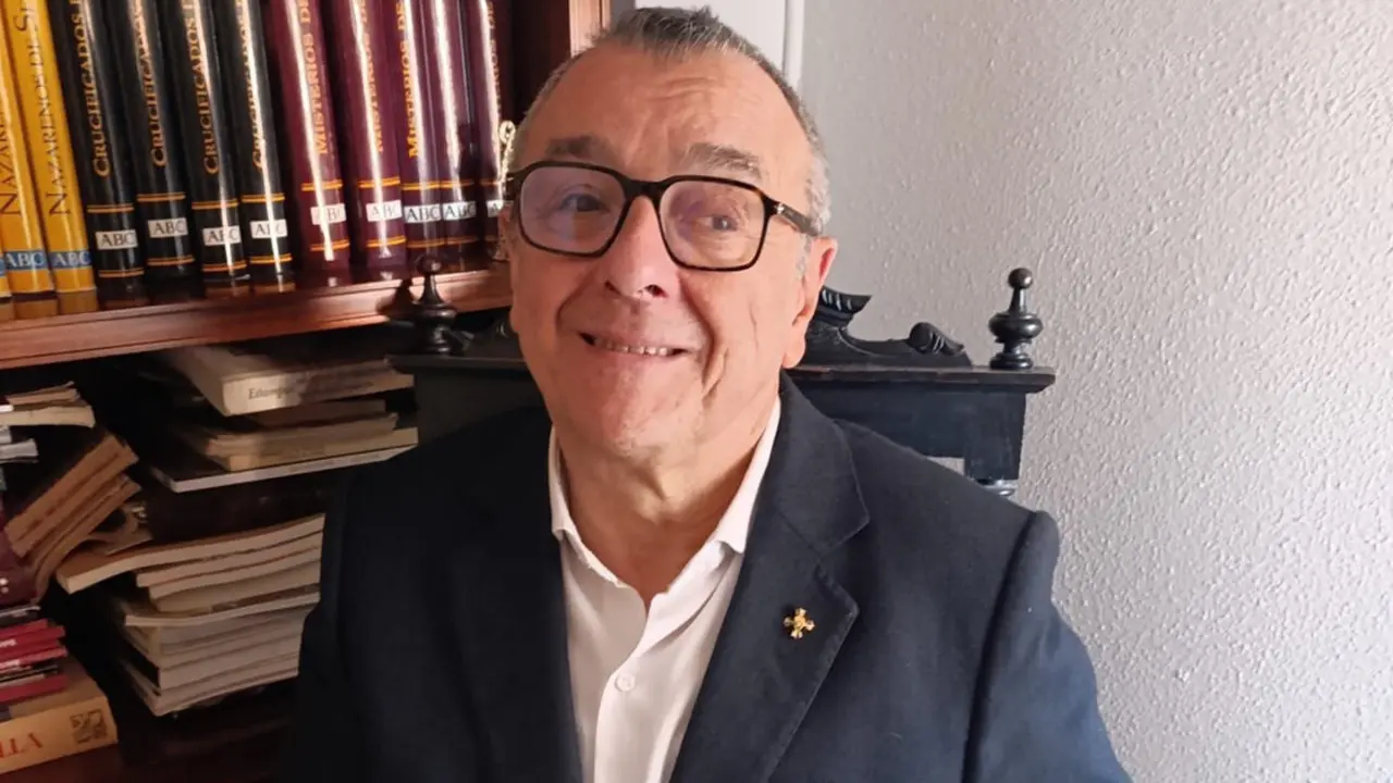 El profesor doctor Carlos José Romero Mensaque con su libro 'Conflictos y pleitos de las hermandades de Sevilla'. | E.P.