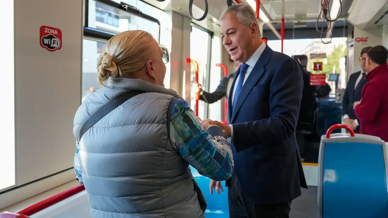 Sanz habla con una vecina en un autob&uacute;s de Tussam. | Archivo