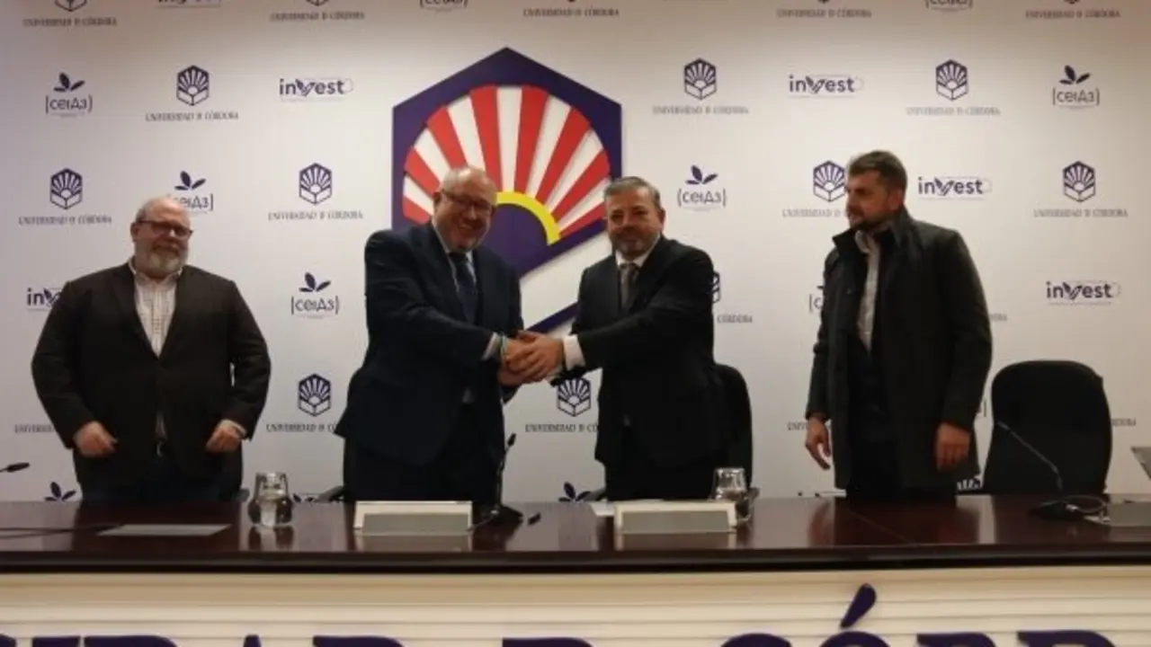 Representantes de ambas instituciones estrechan sus manos tras la firma del acuerdo.