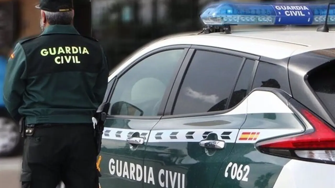 Un agente junto a un veh&iacute;culo oficial, en una imagen de archivo | Guardia Civil