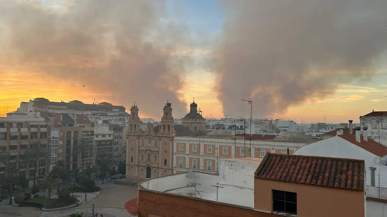Las dos columnas de humo del incendio, sobre la ciudad de Huelva al atardecer. | Vgpalacios.